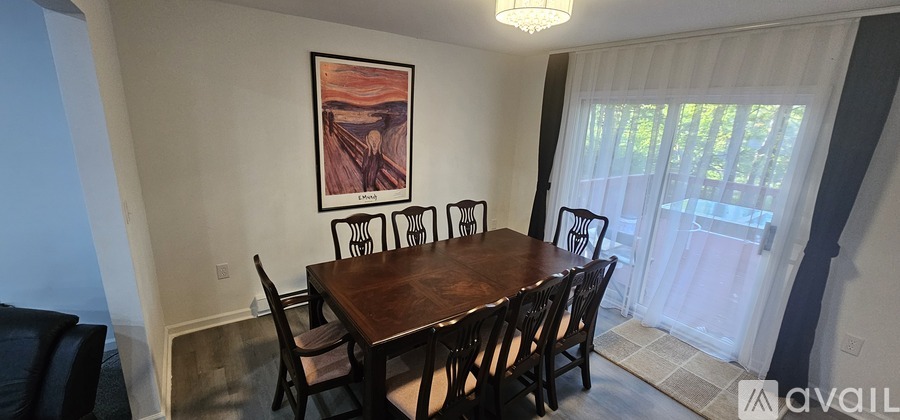 A dining room with a wooden table and chairs.