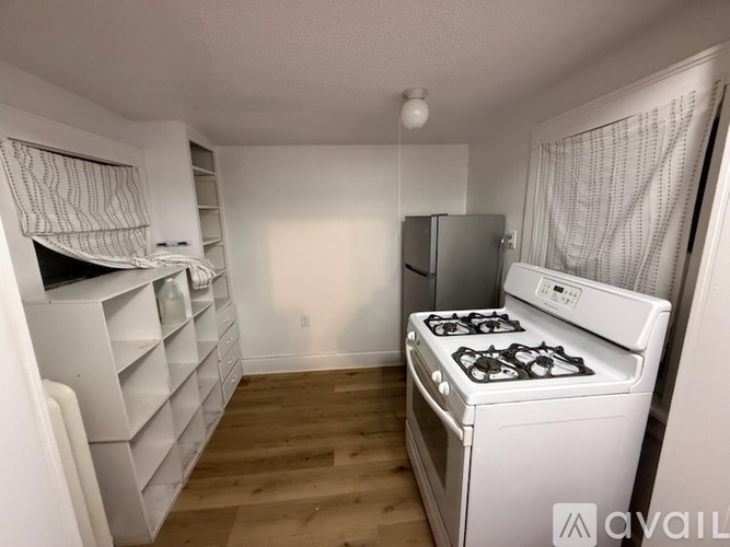 A kitchen with a stove, refrigerator, and cabinets.