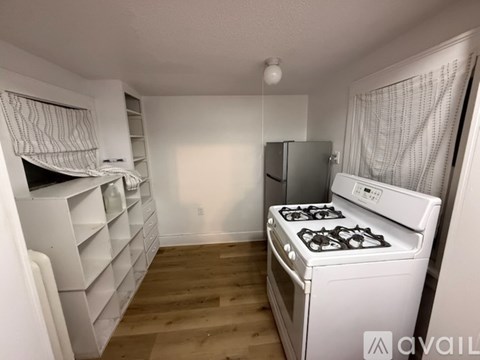A kitchen with a stove, refrigerator, and cabinets.