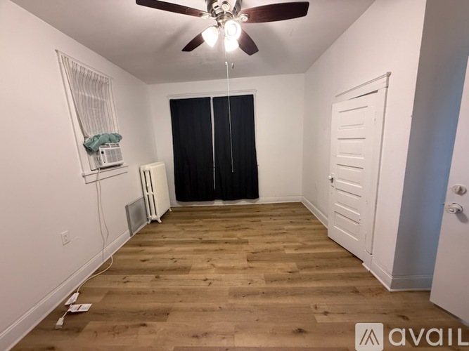 A room with wooden flooring and a ceiling fan.