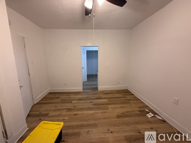A room with wooden flooring and a ceiling fan.
