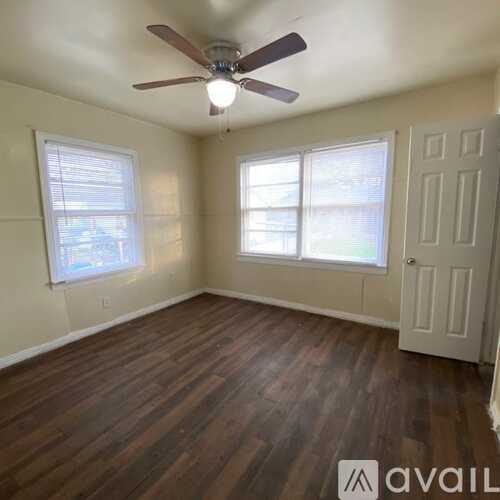 A kitchen with white cabinets and a window.