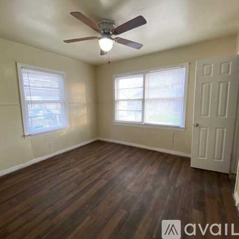 A kitchen with white cabinets and a window.