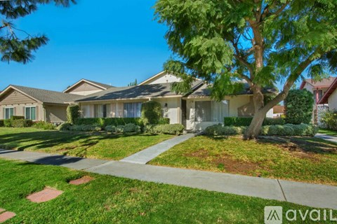 A row of houses with a tree in front of the first one.