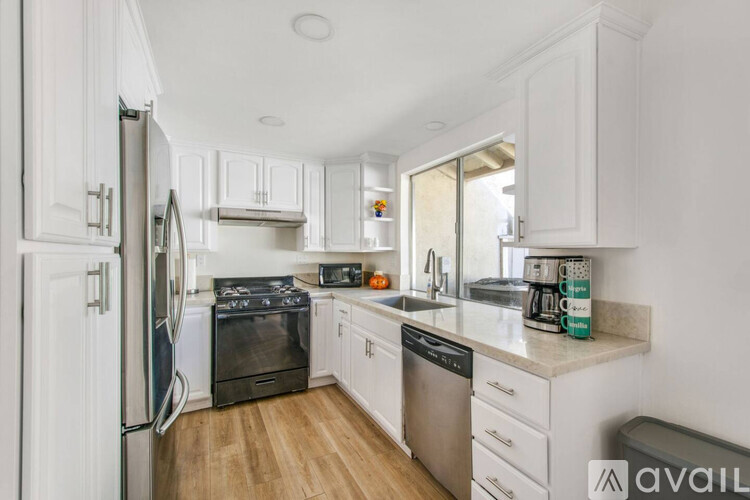 A kitchen with white cabinets and stainless steel appliances.
