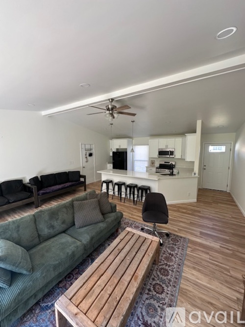 A living room with a couch, chairs, and a coffee table.