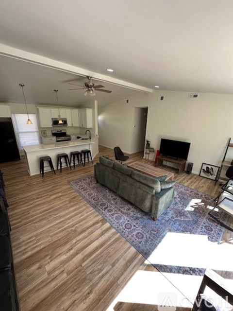 A living room with a grey couch and a wooden floor.