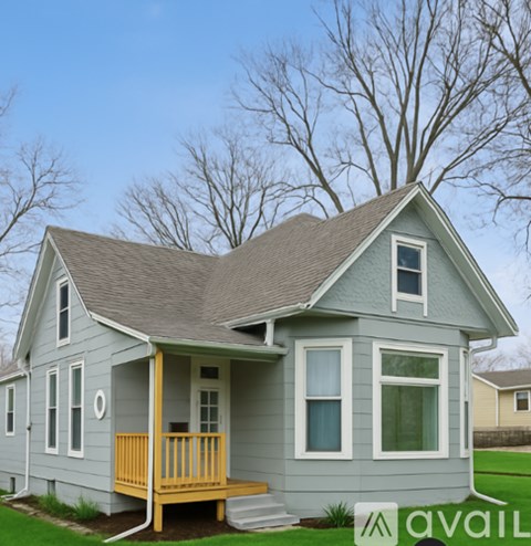 A house with a grey exterior and a yellow porch.