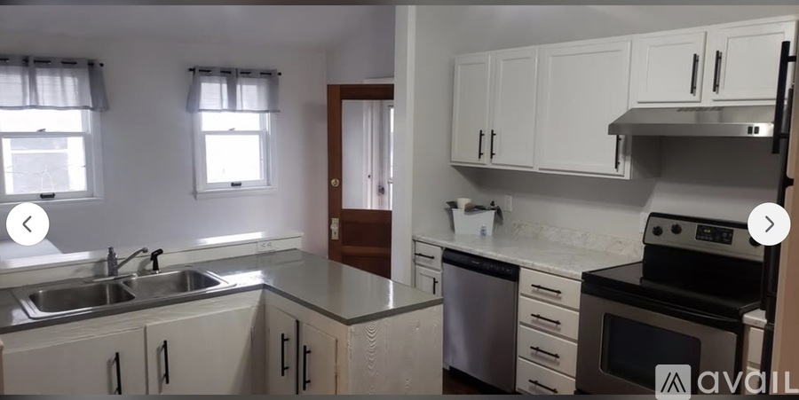 A kitchen with white cabinets and a stove top oven.