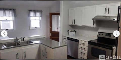 A kitchen with white cabinets and a stove top oven.