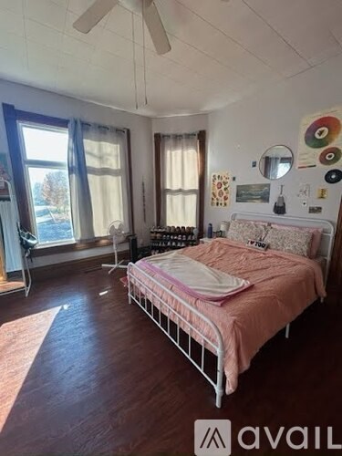 A bedroom with a bed, a chair, and a window.