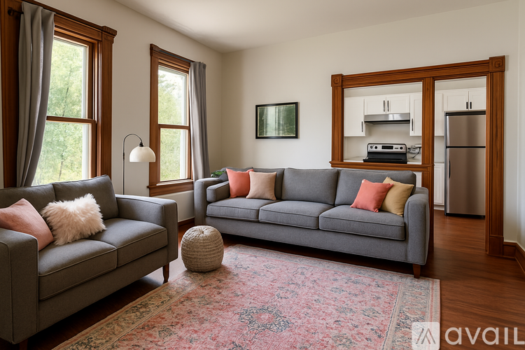 A living room with a grey couch and a rug.