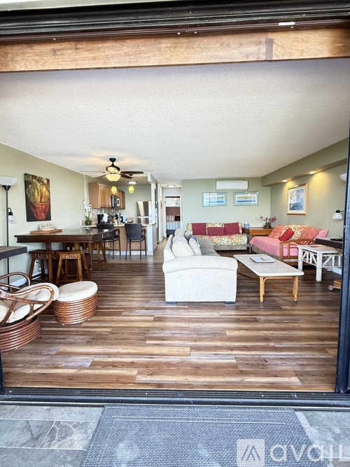 A living room with a white couch and wooden floors.