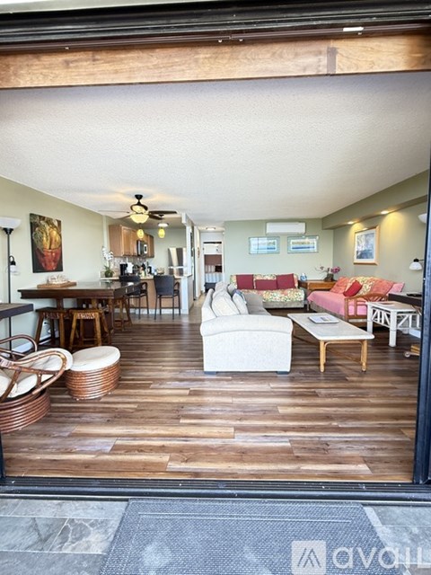 A living room with a white couch and wooden floors.