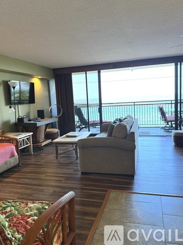 A living room with a large window overlooking the ocean.
