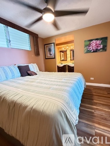 A bedroom with a bed and a ceiling fan.