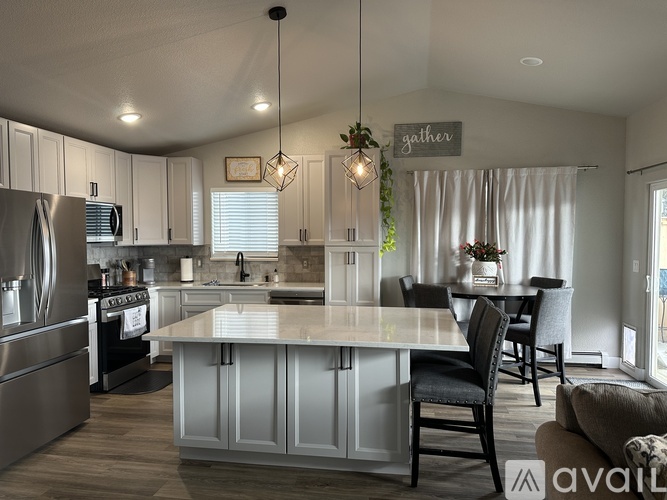 A modern kitchen with a center island and a dining area.
