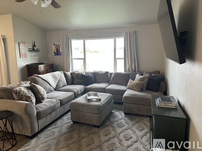 A living room with a grey couch and ottoman.