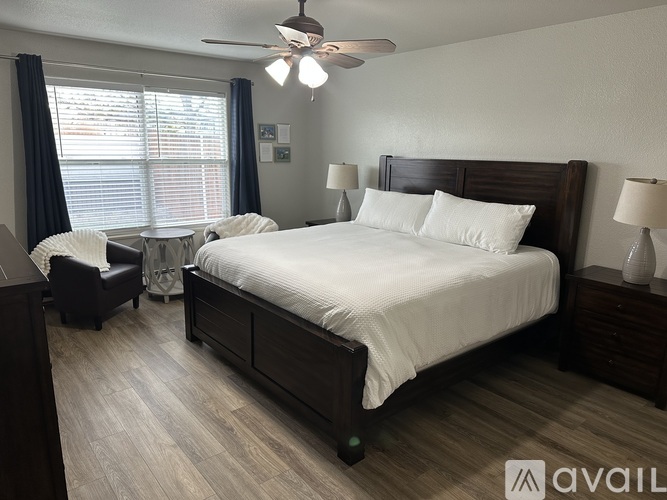 A bedroom with a large bed and a ceiling fan.