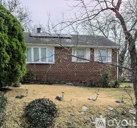 A house with a lawn and trees in front.