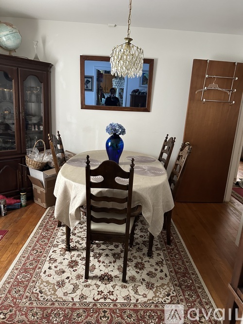 A dining room with a table set for two and a chandelier hanging from the ceiling.