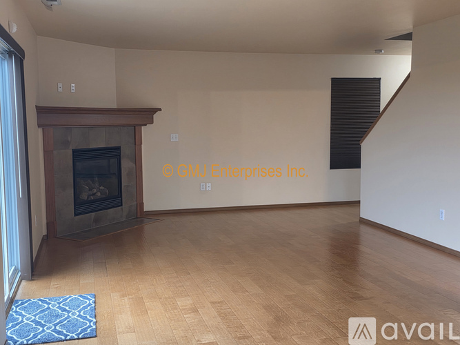A living room with a fireplace and wooden floors.