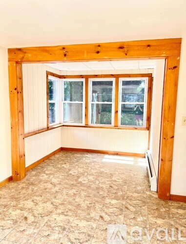 A room with a window and a wooden frame.