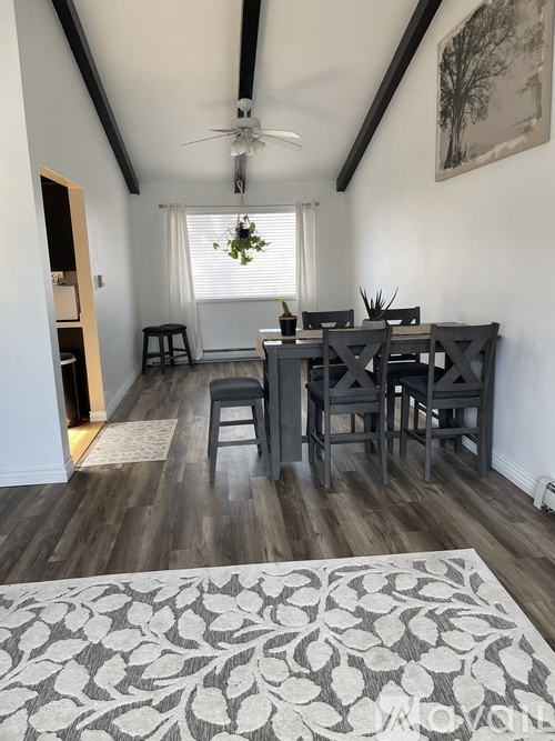 A dining room with a table and chairs.