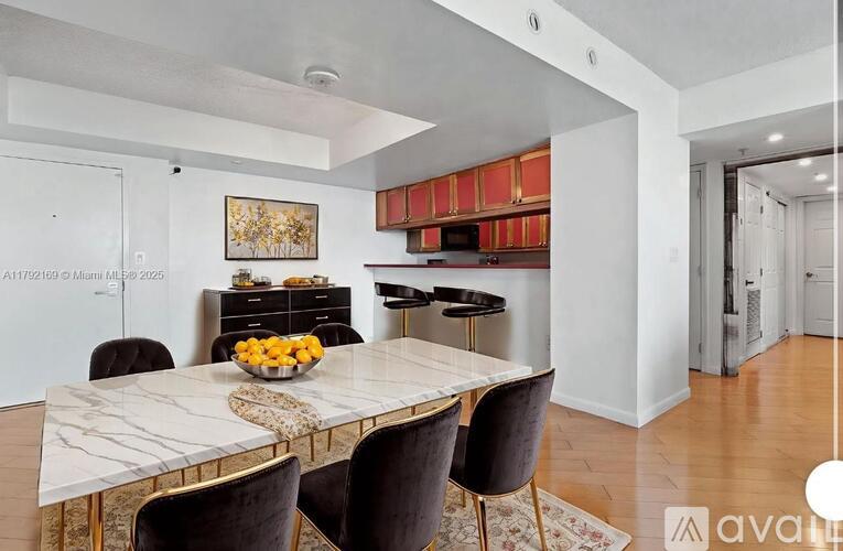 A modern dining room with a marble table and chairs.