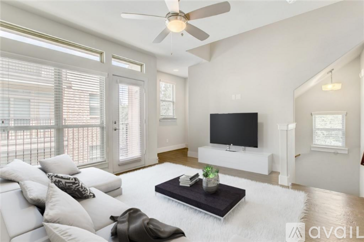 A living room with a white couch and a flat screen TV.