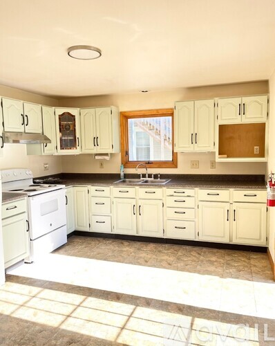 A kitchen with white appliances and cabinets.