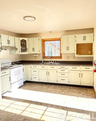 A kitchen with white appliances and cabinets.
