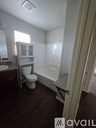 A bathroom with a toilet, sink, and bathtub.