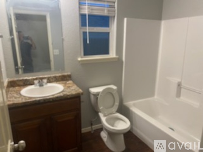 A bathroom with a toilet, sink, and bathtub.