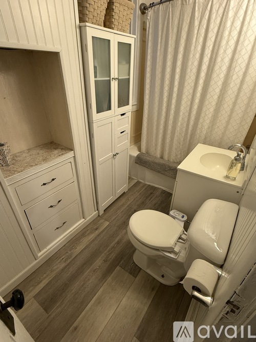 A bathroom with a toilet, sink, and shower.