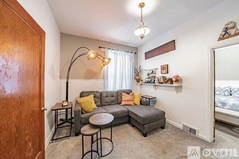 A living room with a grey couch and a black floor lamp.