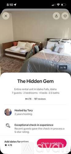 A bedroom with a bed and a bench is shown in the image.