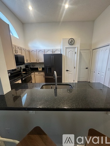 A kitchen with black countertops and white cabinets.