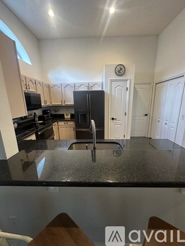 A kitchen with black countertops and white cabinets.