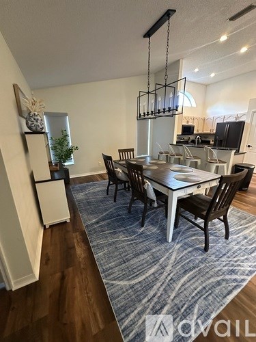 A dining room with a table and chairs.