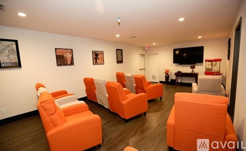 A living room with orange chairs and a television.