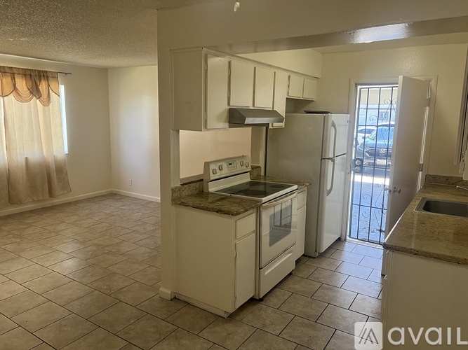 A kitchen with a refrigerator, oven, and sink.