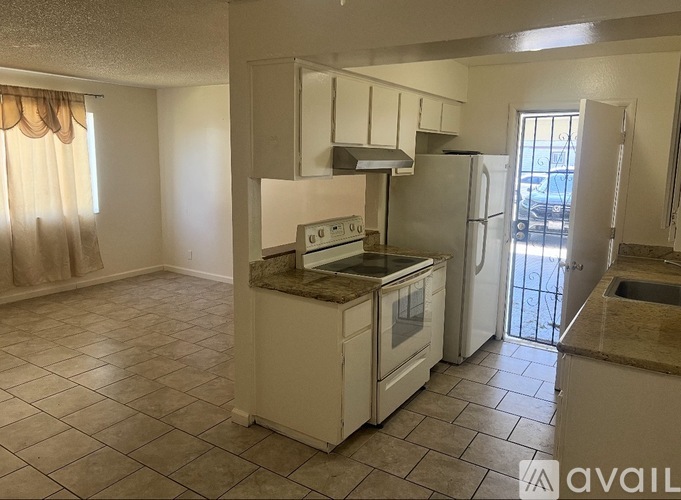 A kitchen with a white stove top oven and white refrigerator.