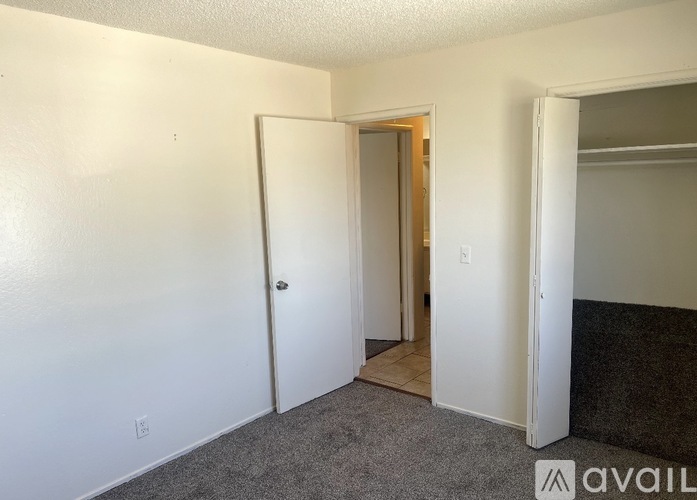 A room with a carpeted floor and a white door.