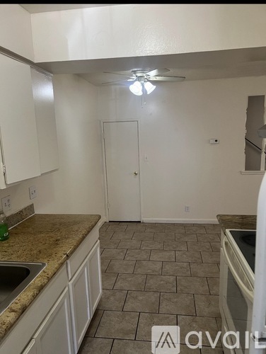 A kitchen with white cabinets and a tiled floor.