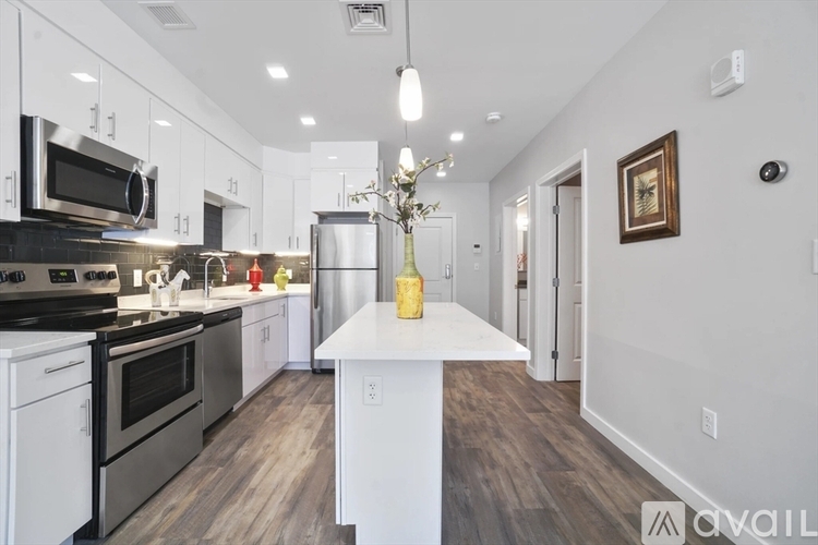 A modern kitchen with stainless steel appliances and white cabinets.