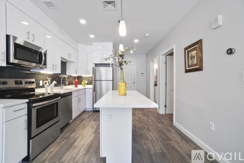 A modern kitchen with stainless steel appliances and white cabinets.