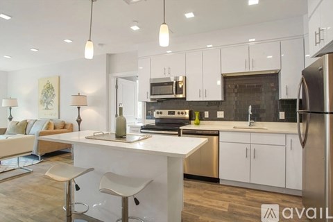 A modern kitchen with white cabinets and a central island.