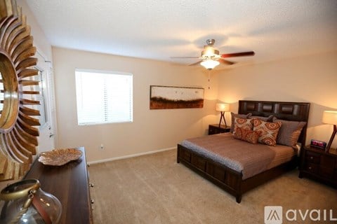 A bedroom with a large bed and a ceiling fan.