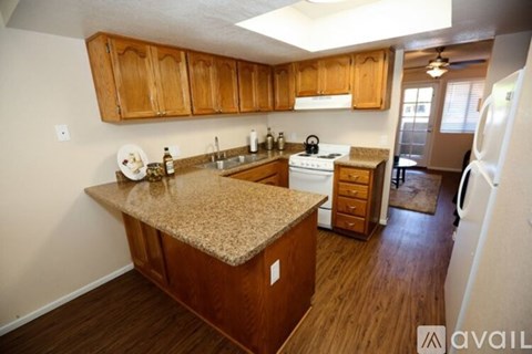 A kitchen with wooden cabinets and a granite countertop.